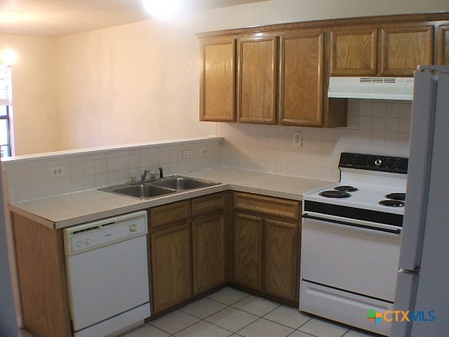 kitchen with light tile patterned floors, white appliances, backsplash, and sink