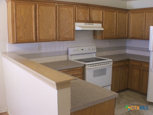 kitchen with electric range, kitchen peninsula, and tasteful backsplash