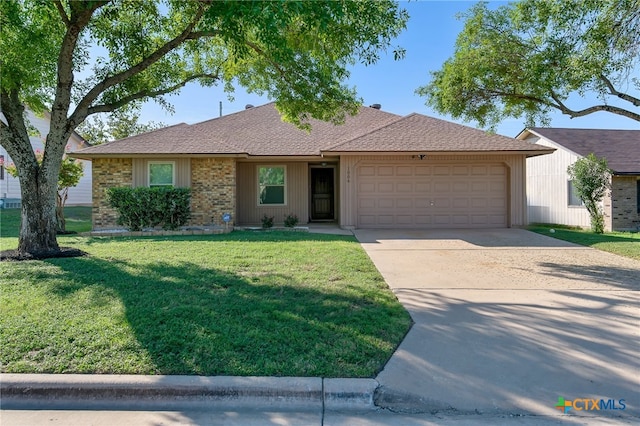 ranch-style home featuring a garage and a front lawn