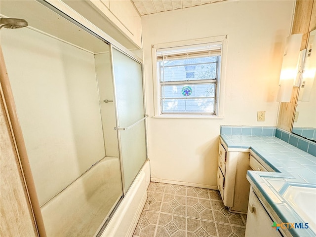 bathroom featuring shower / bath combination with glass door and vanity