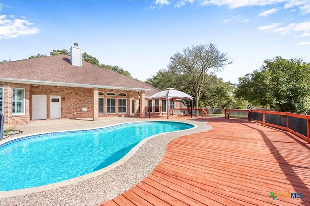 view of pool featuring a patio area, a wooden deck, and a fenced in pool