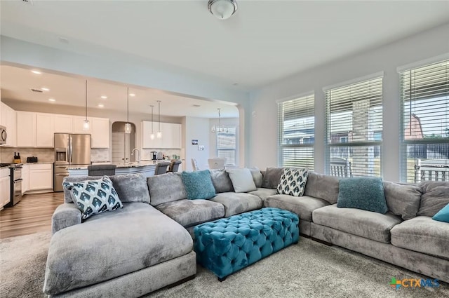 living room featuring a chandelier, hardwood / wood-style floors, and sink