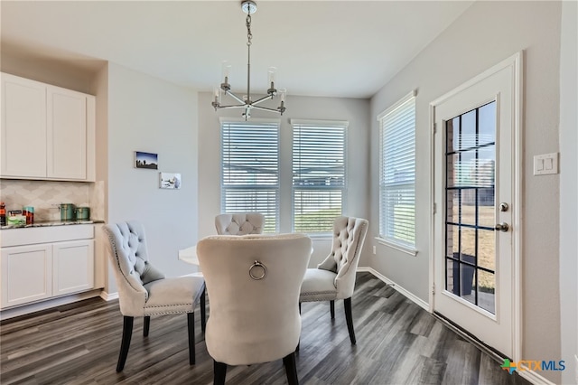 dining room with dark hardwood / wood-style flooring and an inviting chandelier