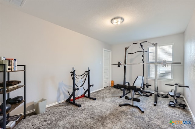 exercise room featuring carpet floors and a textured ceiling