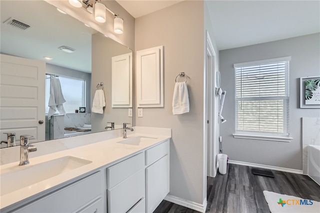 bathroom featuring hardwood / wood-style floors, vanity, and a bath