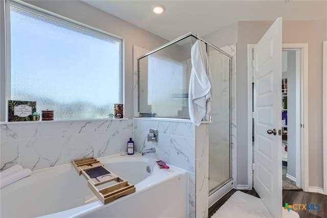 bathroom featuring hardwood / wood-style flooring and plus walk in shower