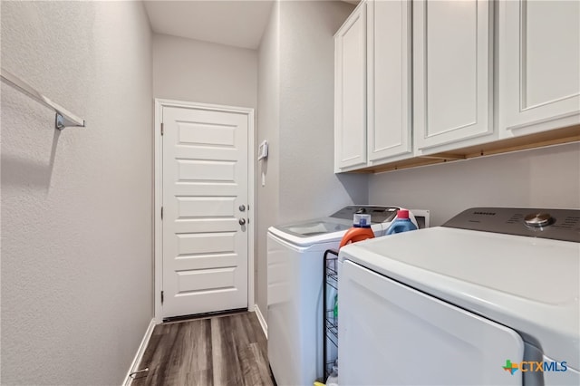 laundry area with dark hardwood / wood-style flooring, cabinets, and independent washer and dryer