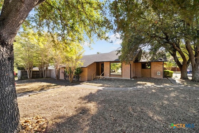 single story home featuring fence and brick siding