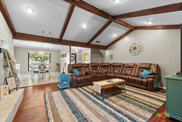 living room with lofted ceiling with beams, hardwood / wood-style flooring, and an inviting chandelier