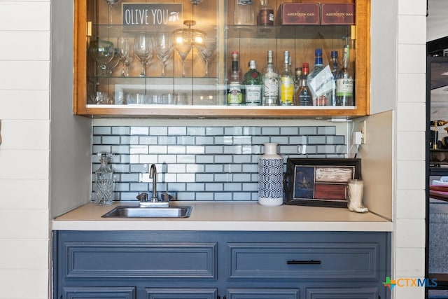 bar with backsplash, sink, and blue cabinets