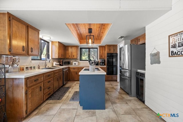 kitchen with brown cabinets, a raised ceiling, a kitchen island, a sink, and black appliances