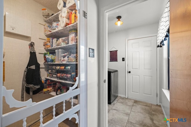 laundry area with light tile patterned floors