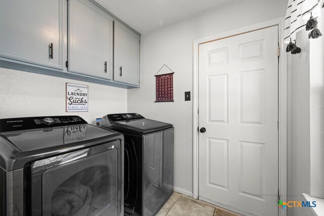 washroom with light tile patterned floors, cabinets, and independent washer and dryer