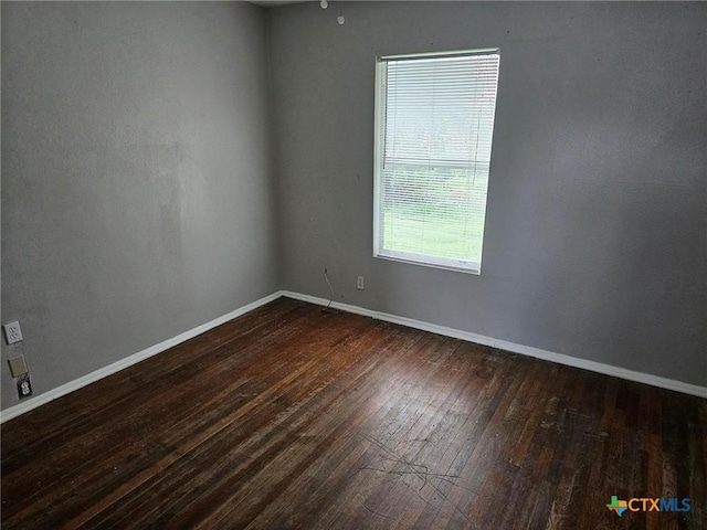 empty room with dark wood-style floors and baseboards