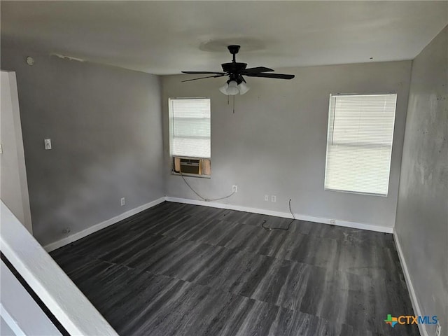 spare room featuring baseboards, cooling unit, ceiling fan, and dark wood-style floors