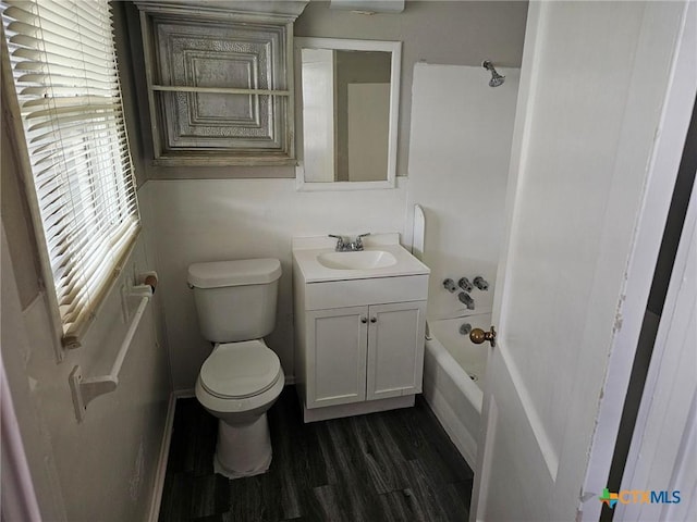 bathroom with toilet, wood finished floors, vanity, and bathtub / shower combination