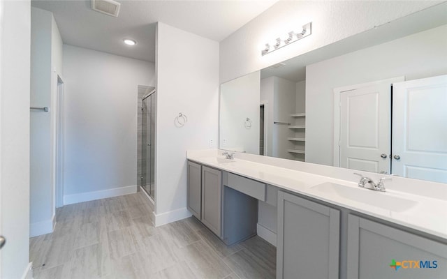 bathroom with vanity and a shower with door