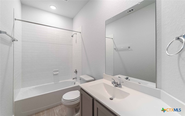 full bathroom featuring vanity, tiled shower / bath, toilet, and hardwood / wood-style floors