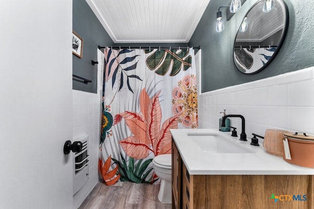 bathroom featuring toilet, hardwood / wood-style floors, tile walls, vanity, and a shower with curtain