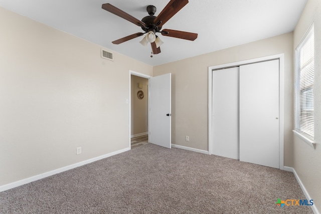 unfurnished bedroom with carpet, a closet, and ceiling fan