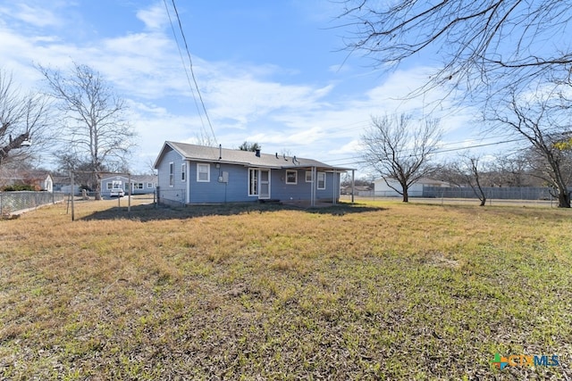 rear view of house featuring a yard