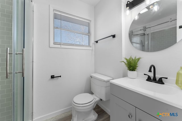 bathroom with wood-type flooring, toilet, an enclosed shower, and vanity