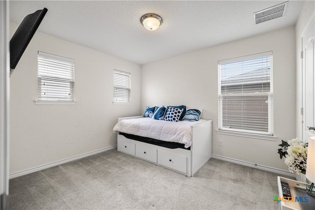 carpeted bedroom featuring baseboards and visible vents