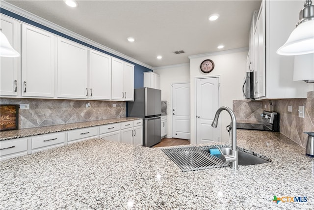 kitchen with a sink, stainless steel appliances, crown molding, visible vents, and white cabinets