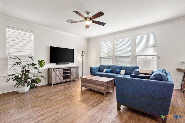 living area featuring light wood finished floors, ceiling fan, crown molding, visible vents, and baseboards