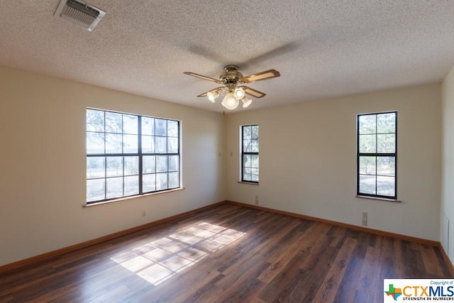 121 S Scenic Loop, Canyon Lake, TX 78133 - empty room with ceiling fan, healthy amount of natural light, wood finished floors, a textured ceiling, and baseboards