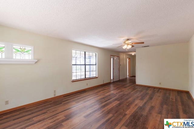 121 S Scenic Loop, Canyon Lake, TX 78133 - spare room featuring dark wood finished floors, a ceiling fan, healthy amount of natural light, a textured ceiling, and baseboards