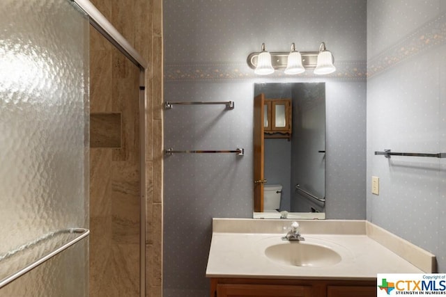 121 S Scenic Loop, Canyon Lake, TX 78133 - bathroom featuring wallpapered walls, toilet, a stall shower, and vanity