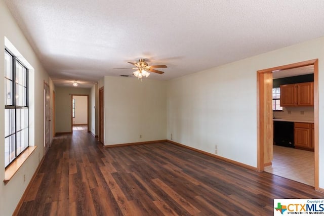 121 S Scenic Loop, Canyon Lake, TX 78133 - spare room with dark wood-style flooring, ceiling fan, baseboards, and a textured ceiling