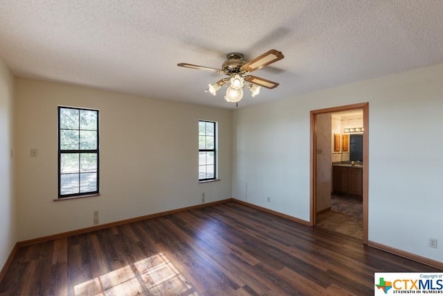 121 S Scenic Loop, Canyon Lake, TX 78133 - spare room with dark wood finished floors, ceiling fan, baseboards, and a textured ceiling