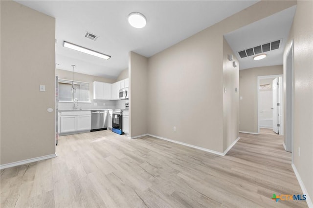 interior space featuring light wood-type flooring, visible vents, a sink, and baseboards