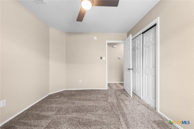 unfurnished bedroom with a ceiling fan, carpet, a closet, and baseboards