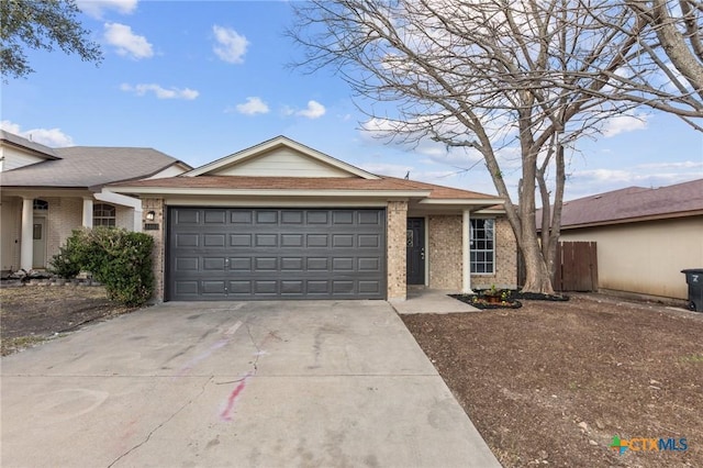 single story home featuring brick siding, driveway, an attached garage, and fence