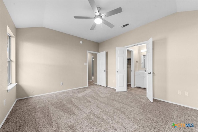 unfurnished bedroom featuring lofted ceiling, multiple windows, and carpet floors