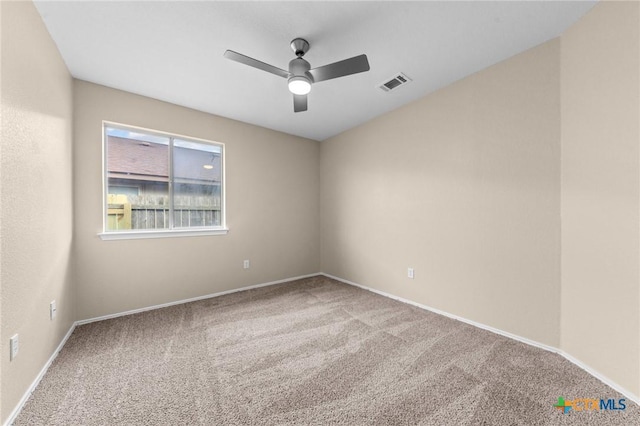 empty room featuring carpet, visible vents, ceiling fan, and baseboards