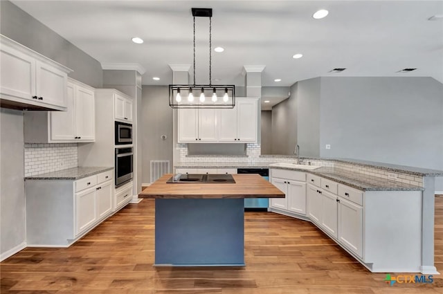 105 Legend Dr, Victoria, TX 77904 - kitchen featuring stainless steel appliances, a sink, butcher block counters, a peninsula, and decorative backsplash