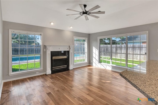 105 Legend Dr, Victoria, TX 77904 - unfurnished living room featuring wood finished floors, a ceiling fan, a fireplace with flush hearth, baseboards, and lofted ceiling