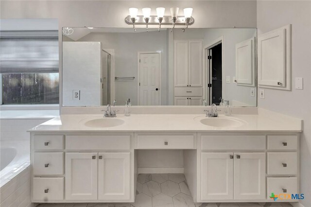105 Legend Dr, Victoria, TX 77904 - bathroom with tile patterned flooring, double vanity, a bath, and a shower with door