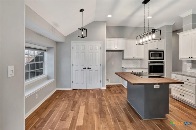 105 Legend Dr, Victoria, TX 77904 - kitchen with wooden counters, stainless steel appliances, wood finished floors, white cabinetry, and vaulted ceiling