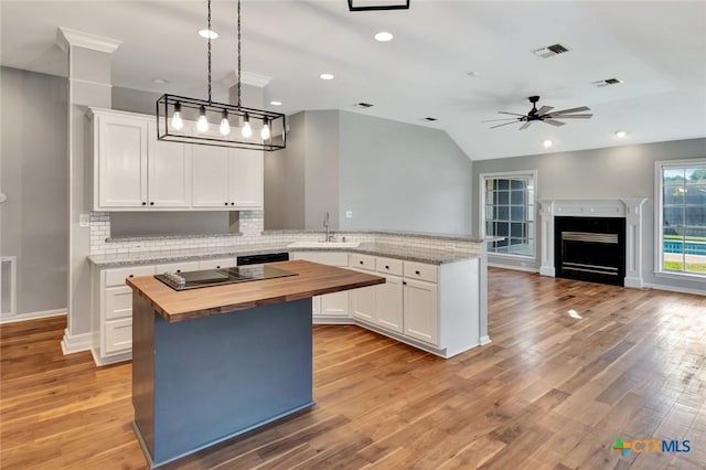 105 Legend Dr, Victoria, TX 77904 - kitchen featuring butcher block counters, a sink, decorative backsplash, white cabinets, and ceiling fan