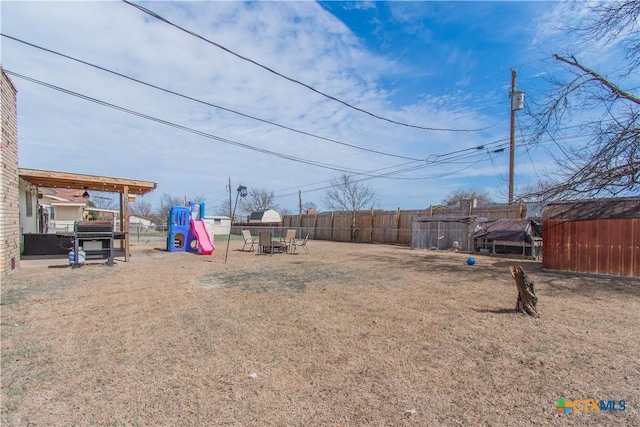 view of yard with a playground and fence