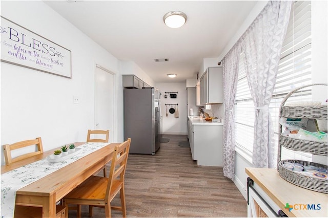 dining area with visible vents, baseboards, and light wood-style floors