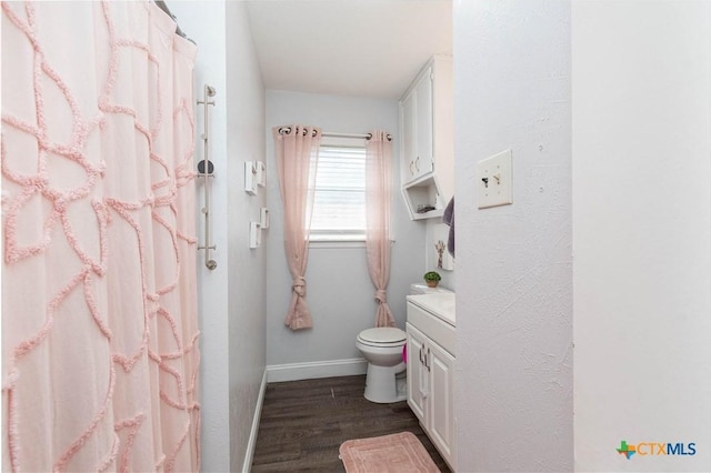 full bathroom featuring vanity, wood finished floors, baseboards, curtained shower, and toilet