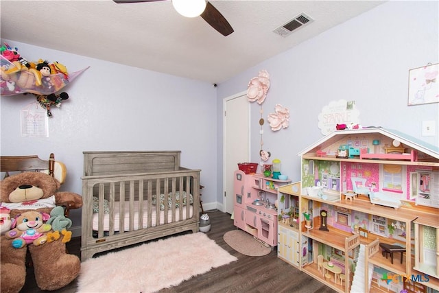 bedroom featuring wood finished floors and visible vents