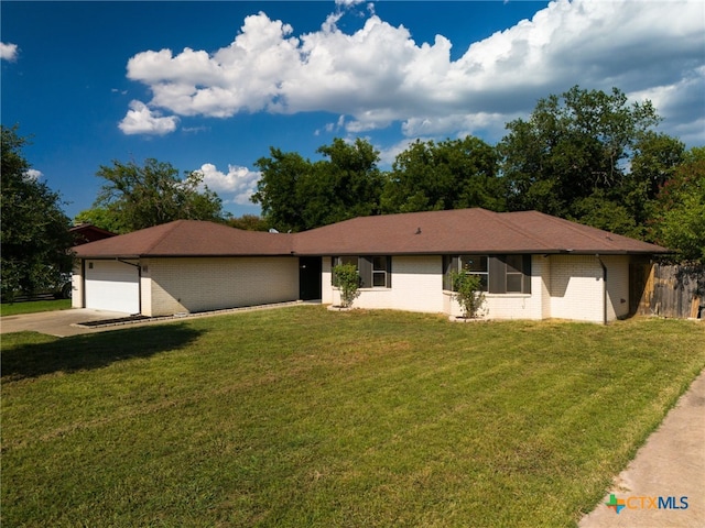 ranch-style home with a garage, driveway, a front lawn, and brick siding