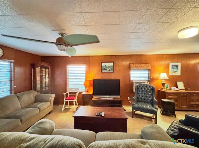 living room with wood walls, ceiling fan, a healthy amount of sunlight, and cooling unit